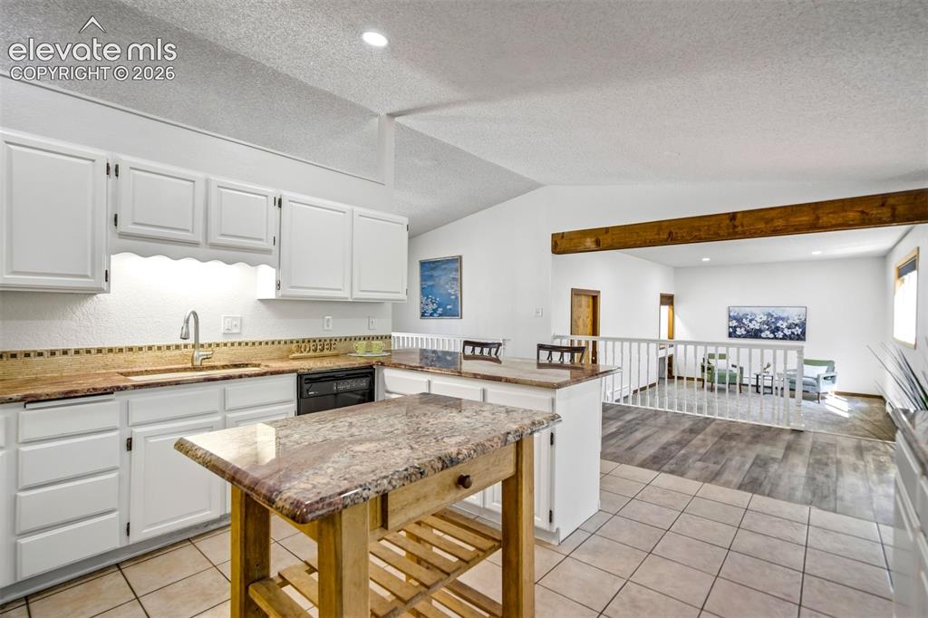 Image 18 of 45: Kitchen featuring white cabinetry, a built-in dishwasher, and a stainless s