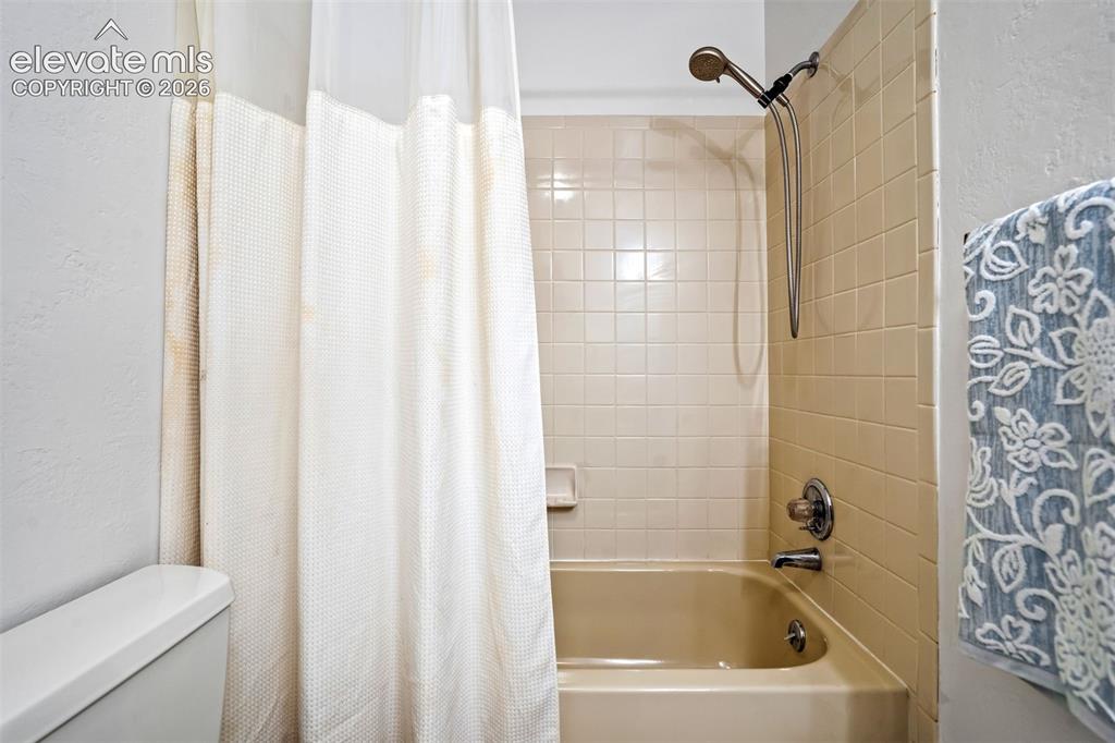 Image 24 of 45: Bathroom featuring a shower/tub combination with beige subway tile surround