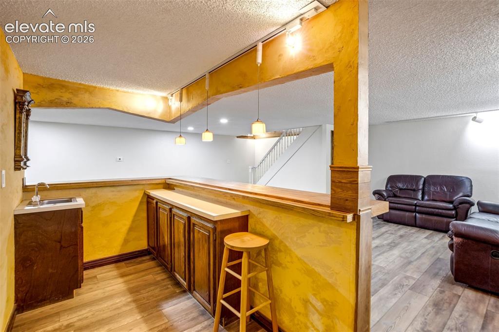 Image 31 of 45: Lower level entertaining area featuring a built-in bar with dark wood cabin