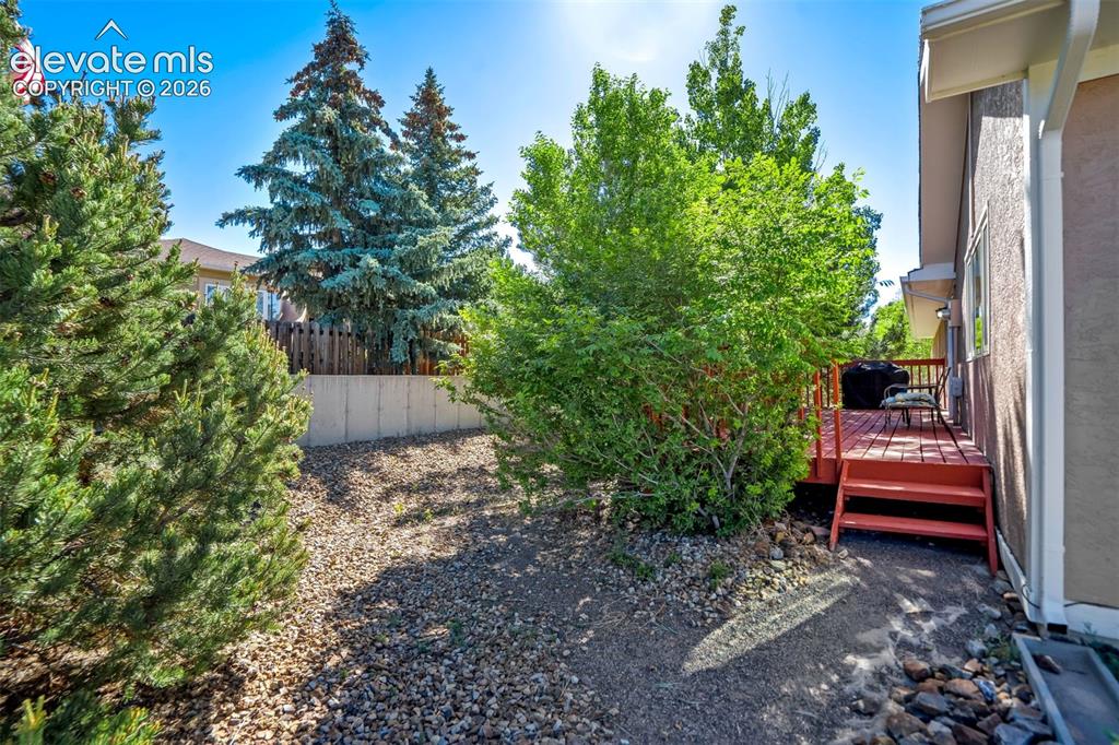 Image 39 of 45: Redwood-toned deck with direct exterior access, featuring a stucco-finish e