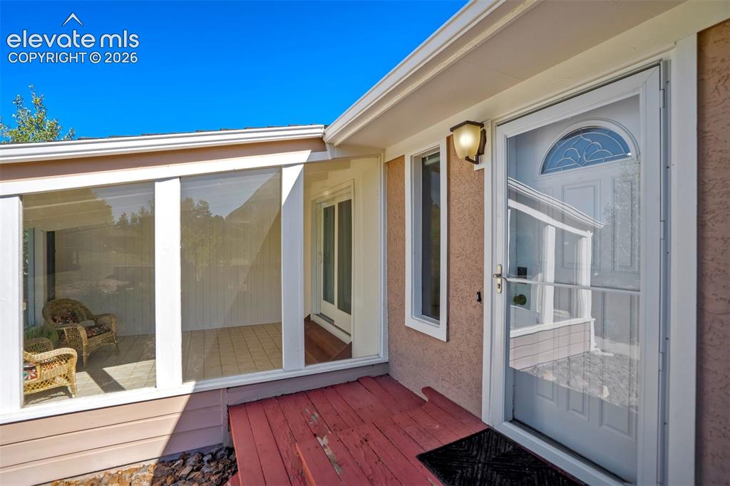 Image 4 of 45: Front entrance featuring a white storm door with an arched decorative glass