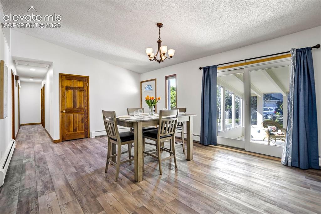 Image 8 of 45: Spacious interior featuring wood-finish flooring, a contemporary chandelier
