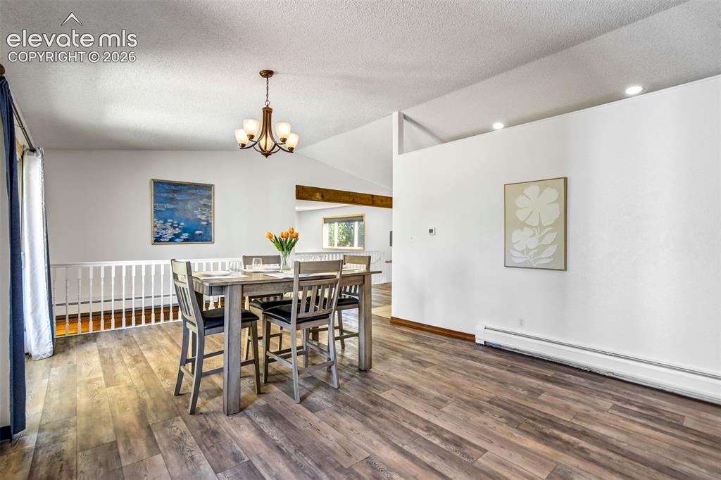 Image 9 of 45: Spacious interior featuring wood-finish flooring, vaulted ceilings, and a b