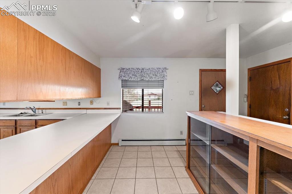 Image 11 of 44: Kitchen with light tile patterned flooring and wooden counters