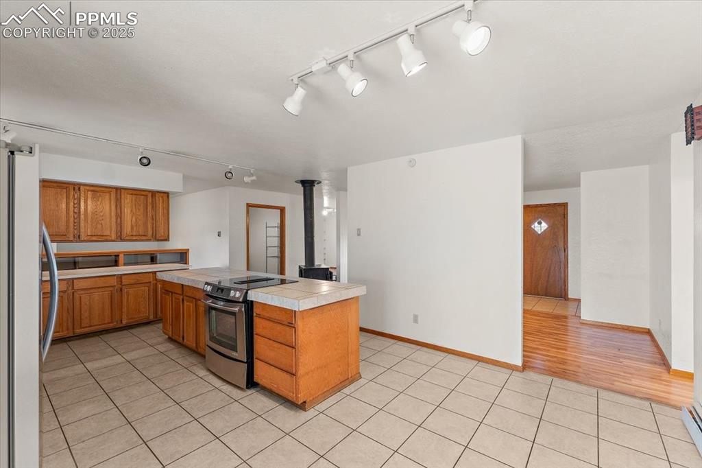 Image 15 of 44: Kitchen featuring stainless steel appliances, light tile patterned flooring