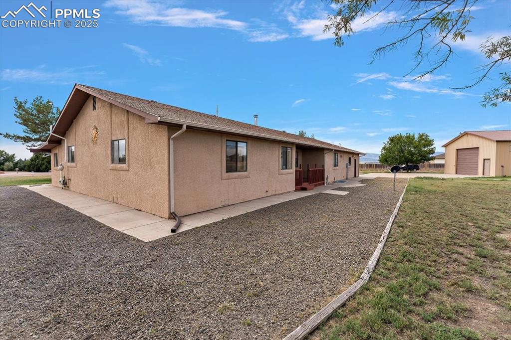 Image 36 of 44: View of side of home featuring stucco siding and an outbuilding