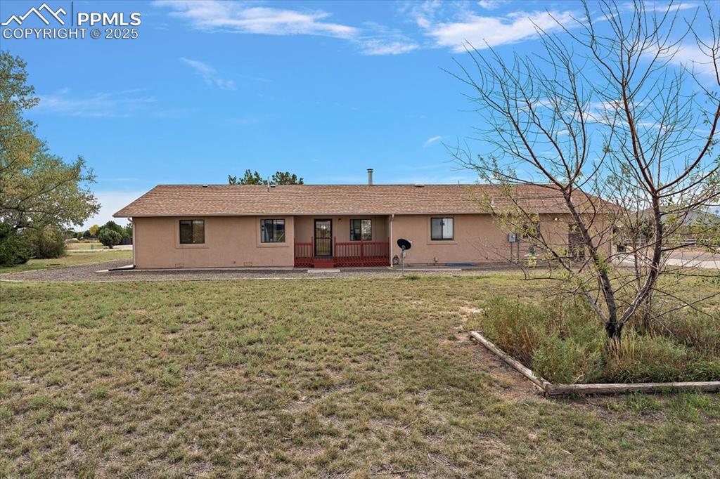 Image 37 of 44: Ranch-style house featuring covered porch, a front lawn, and stucco siding