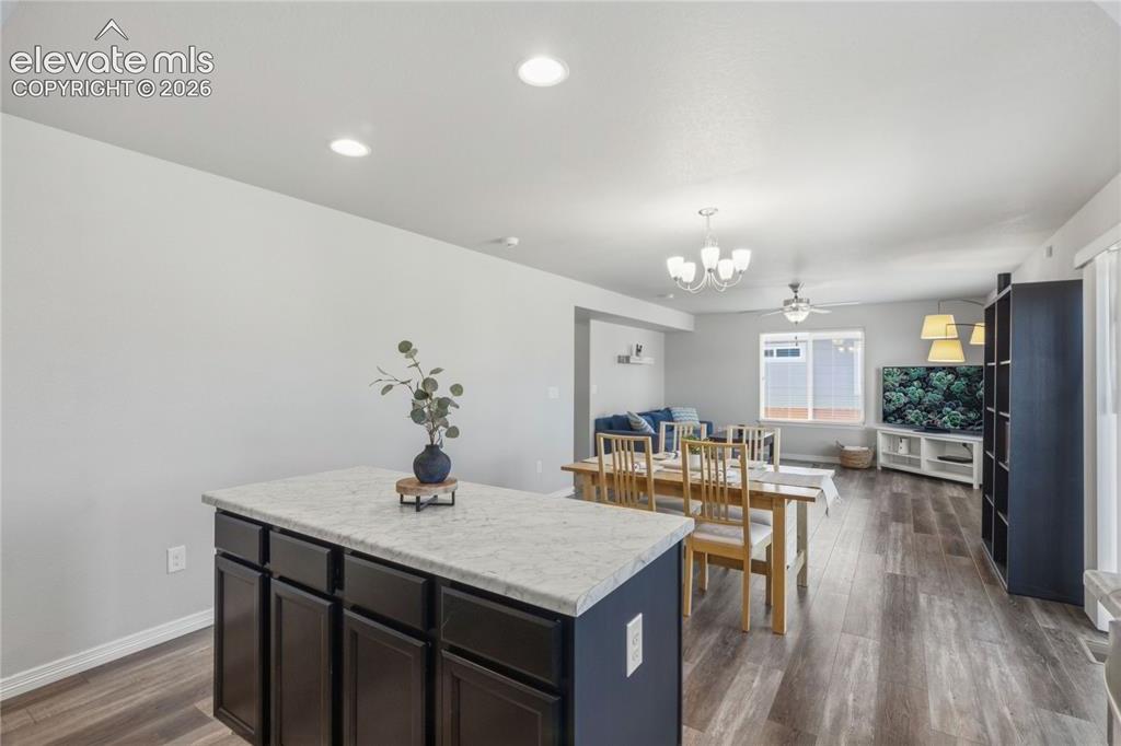 Image 10 of 50: Kitchen island with a light-tonedand dark cabinetry, LVP flooring, recessed