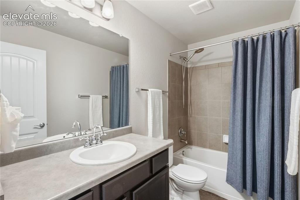 Image 19 of 50: Bathroom featuring an oval undermount sink with chrome fixtures, a dark woo
