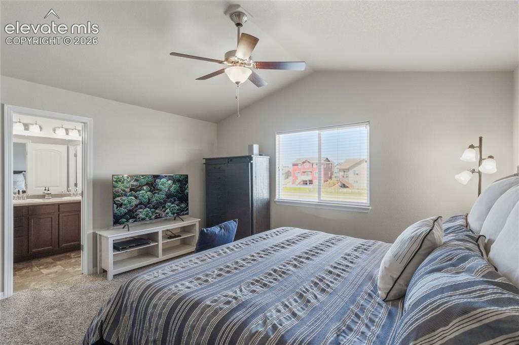Image 27 of 50: Carpeted room featuring a vaulted ceiling with a ceiling fan, a double-pane