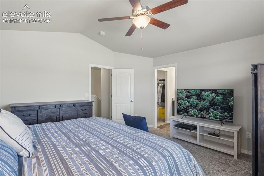 Image 28 of 50: Carpeted room featuring a vaulted ceiling and a ceiling fan with integrated