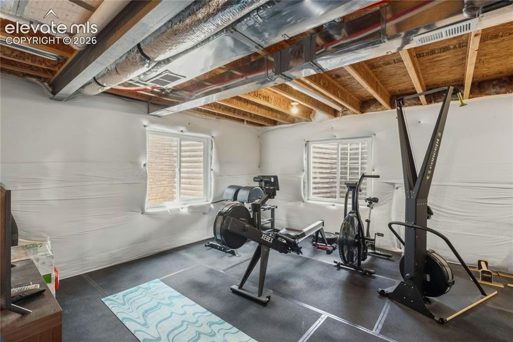 Image 30 of 50: Finished basement space featuring exposed ceiling joists, ductwork, and two