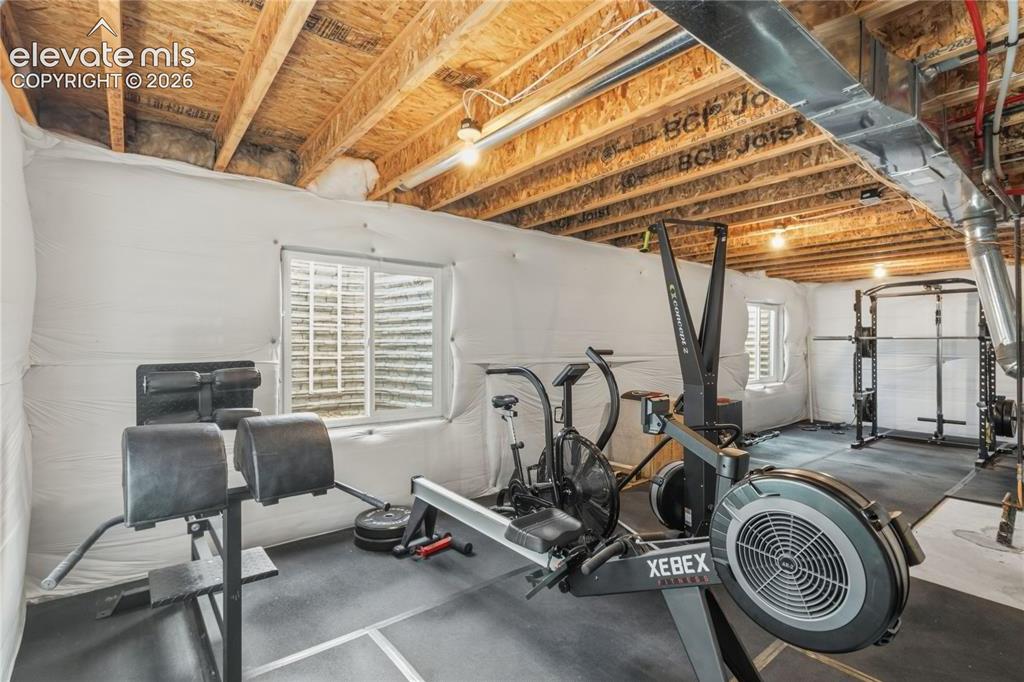 Image 31 of 50: Unfinished basement space featuring exposed wood joists, white insulated wa