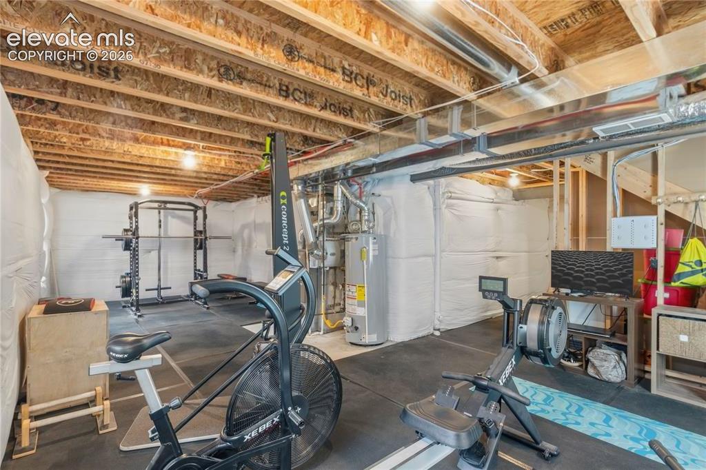 Image 32 of 50: Unfinished basement space featuring exposed wood joists and structural elem