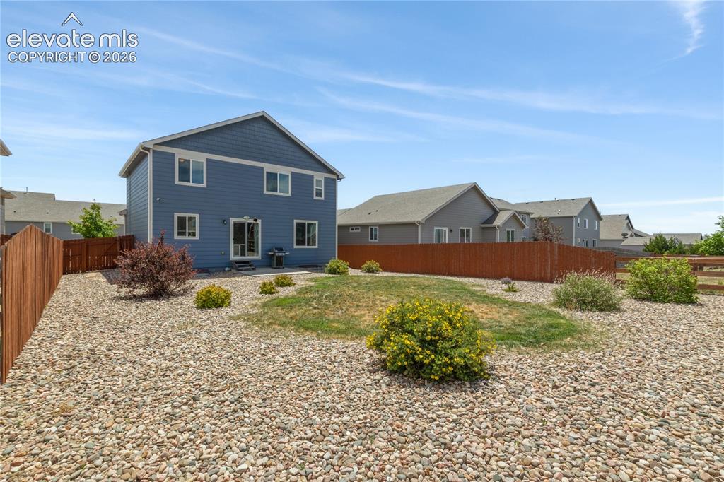 Image 37 of 50: Two-story residence with blue siding and white trim