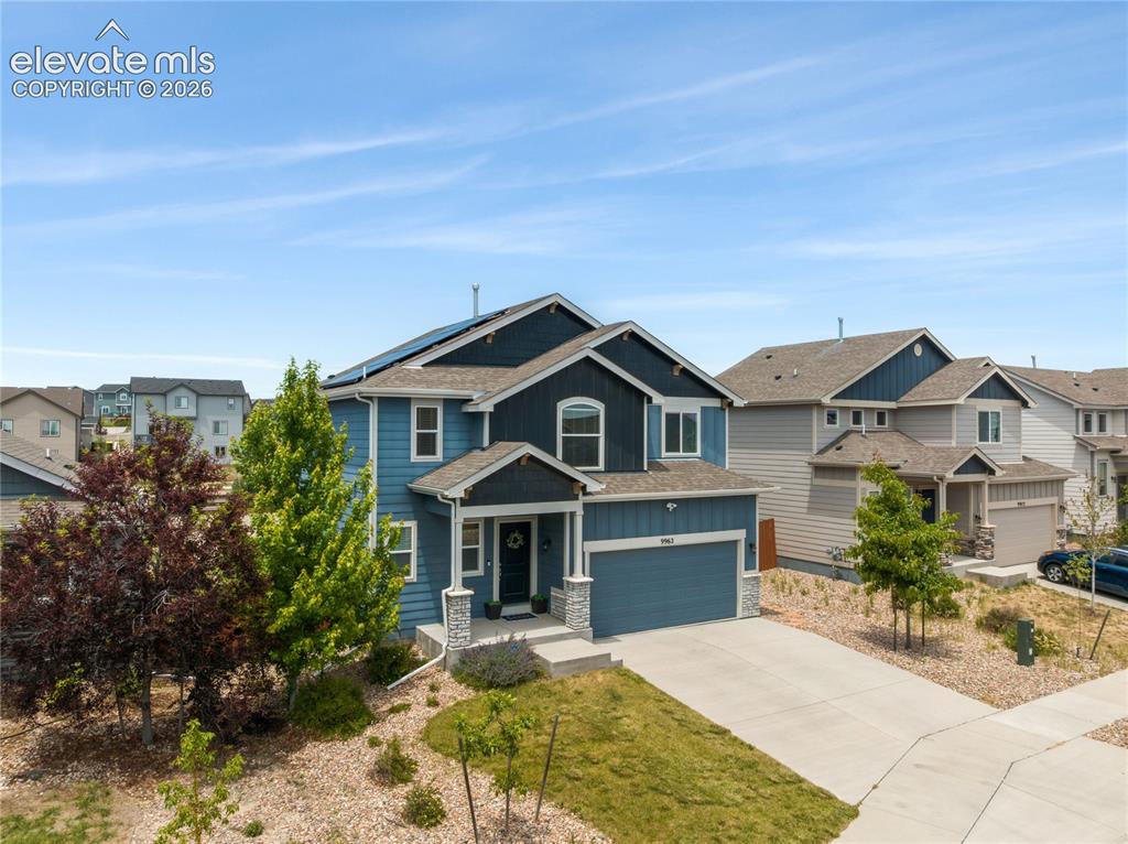 Image 38 of 50: Modern two-story residence with a blue facade and contrasting dark blue acc