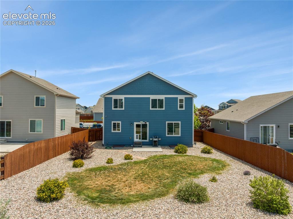 Image 46 of 50: Rear exterior featuring blue siding and white trim