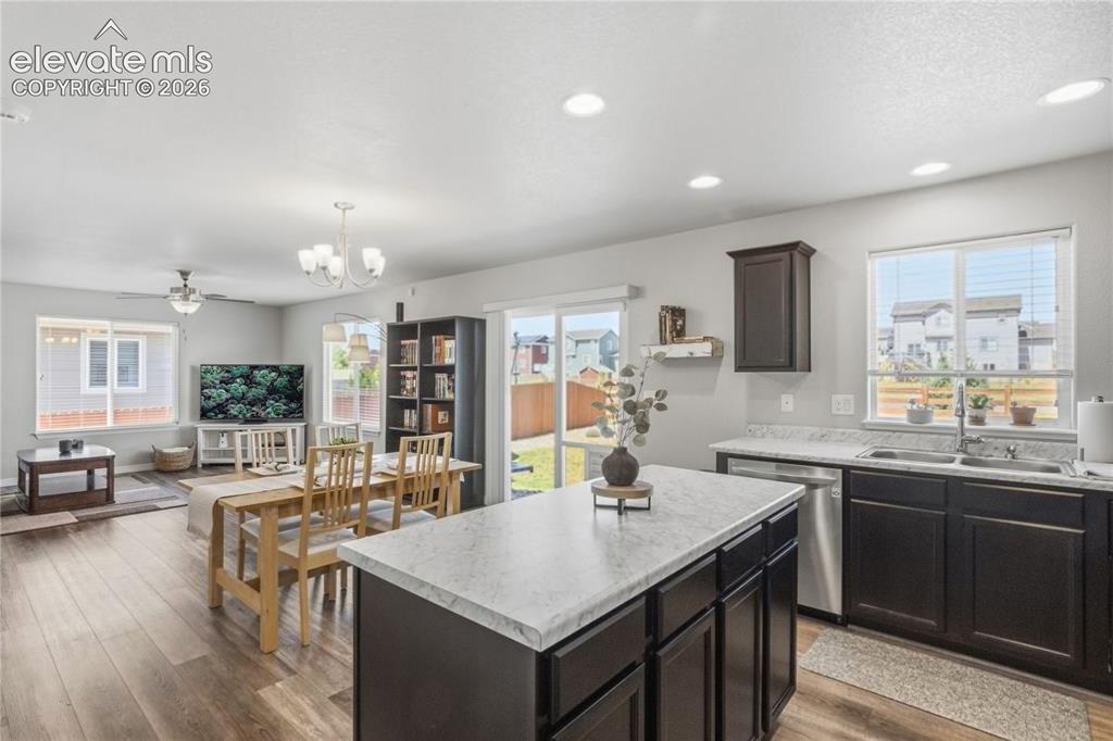 Image 9 of 50: Open-concept living area featuring a kitchen with light countertops, a cen
