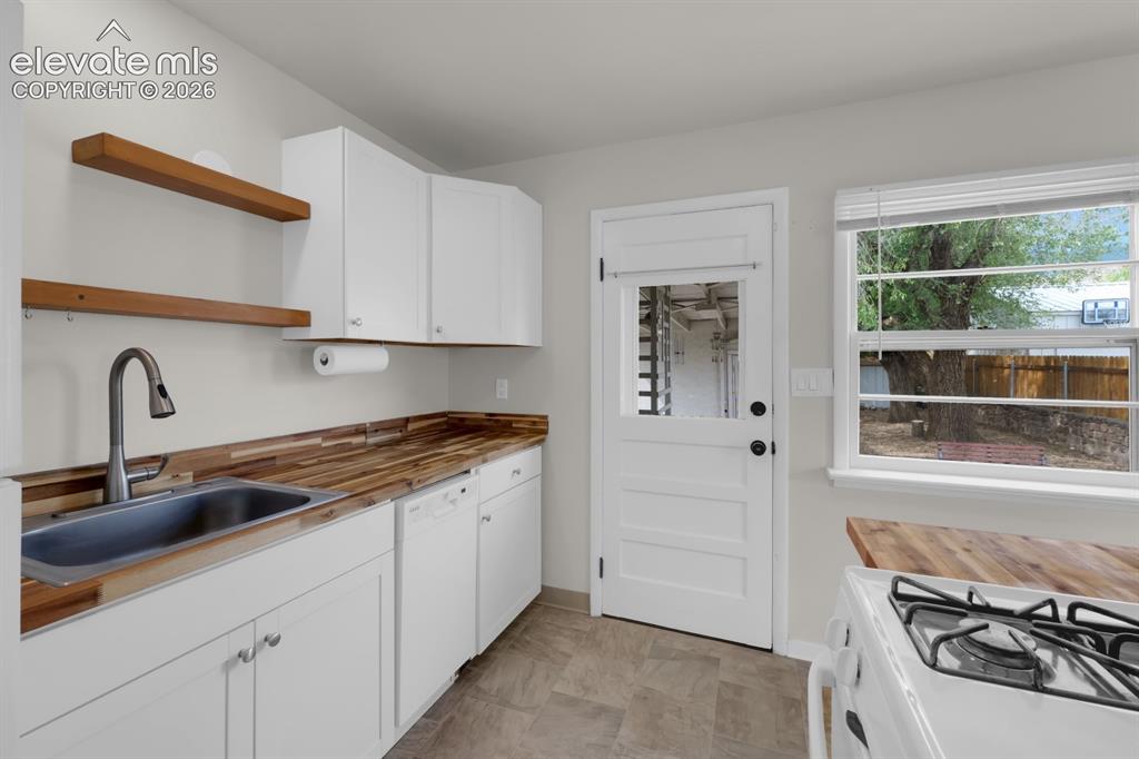 Image 2 of 23: Main-level kitchen with updated and bright kitchen featuring white cabinetr