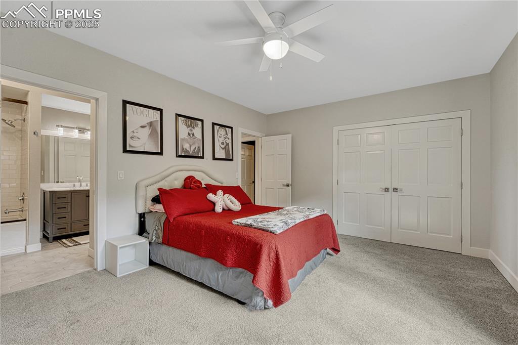 Image 21 of 47: Bedroom featuring carpet floors, a closet, ensuite bathroom, and ceiling fa