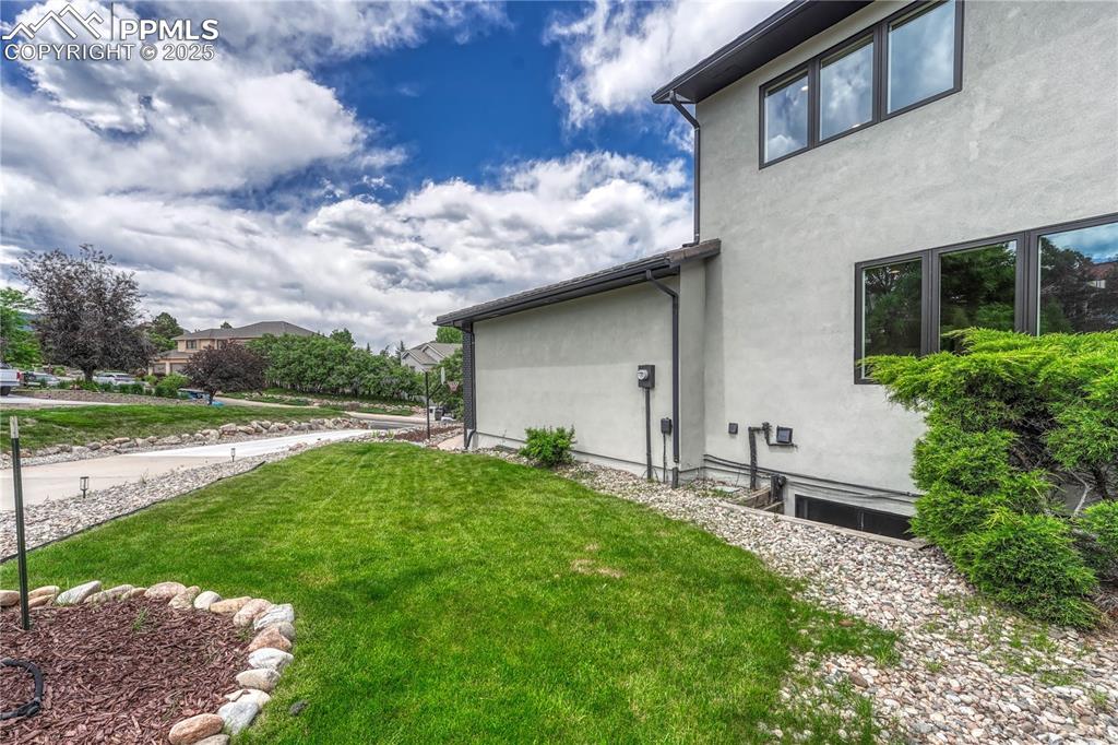 Image 22 of 47: View of side of property featuring stucco siding and a yard