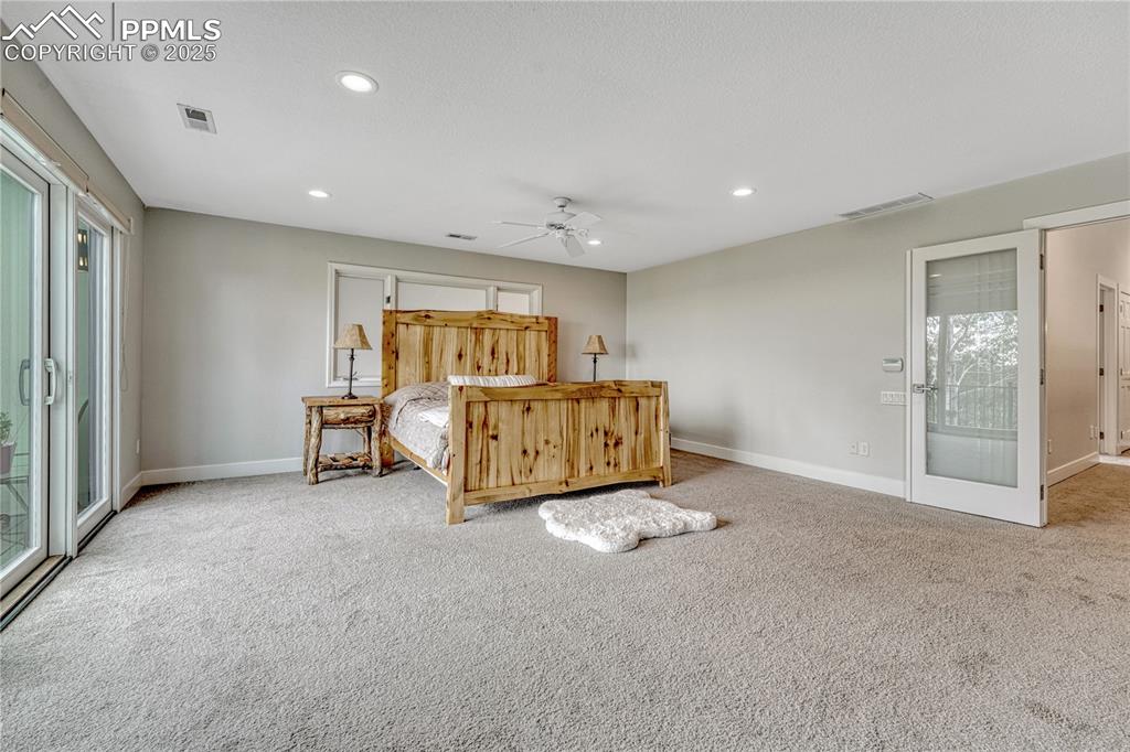Image 29 of 47: Carpeted bedroom featuring multiple windows, recessed lighting, access to e