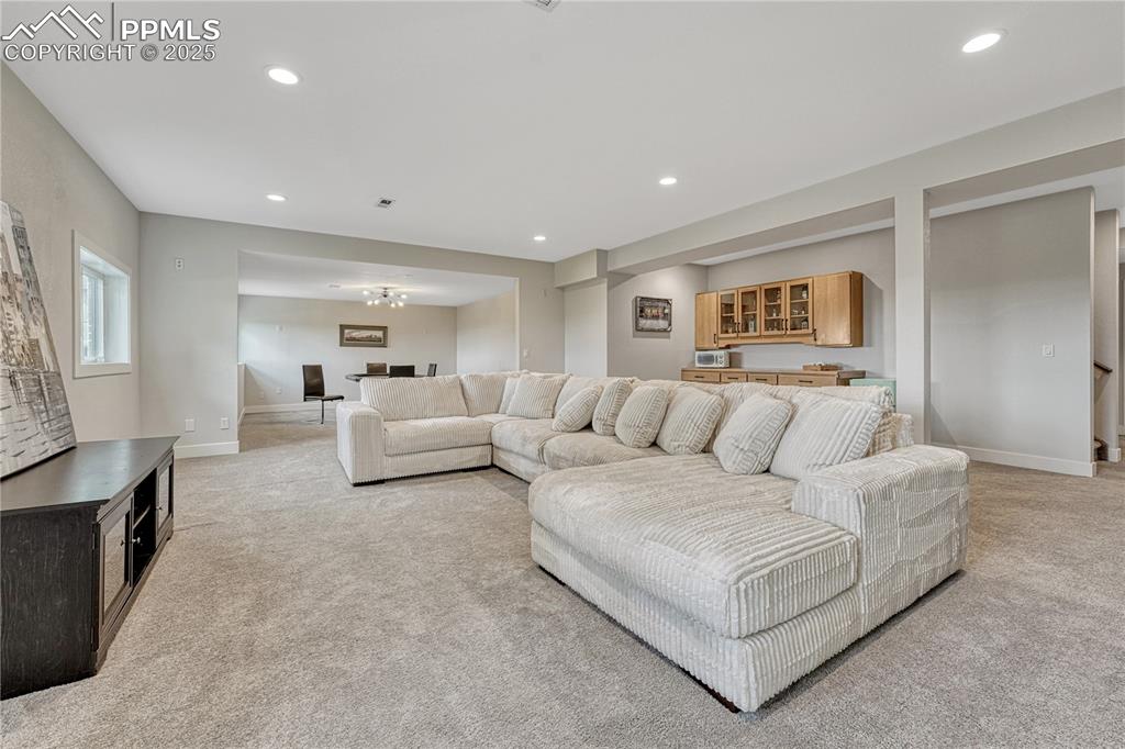 Image 39 of 47: Living room with light carpet and recessed lighting