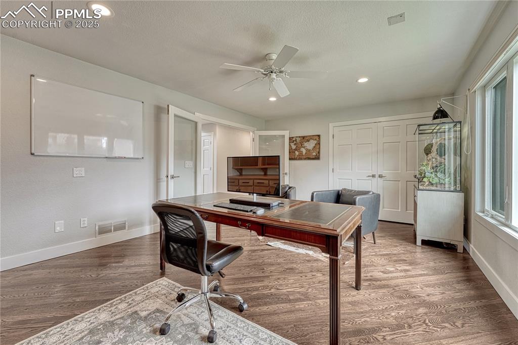 Image 7 of 47: Home office featuring wood finished floors, a ceiling fan, healthy amount o