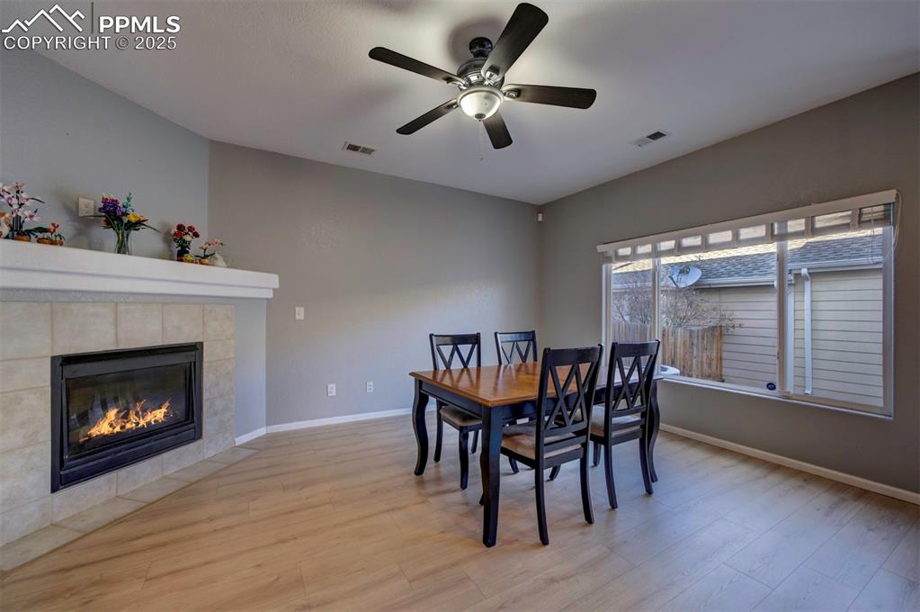 Image 14 of 43: Dining space featuring light wood-type flooring, ceiling fan, and a tiled f