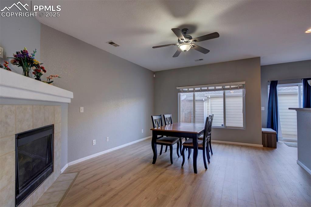 Image 15 of 43: Dining area featuring a fireplace, light wood finished floors, and ceiling 