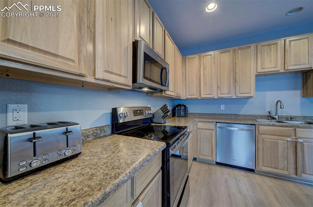 Image 21 of 43: Kitchen featuring stainless steel appliances, light wood finished floors, l
