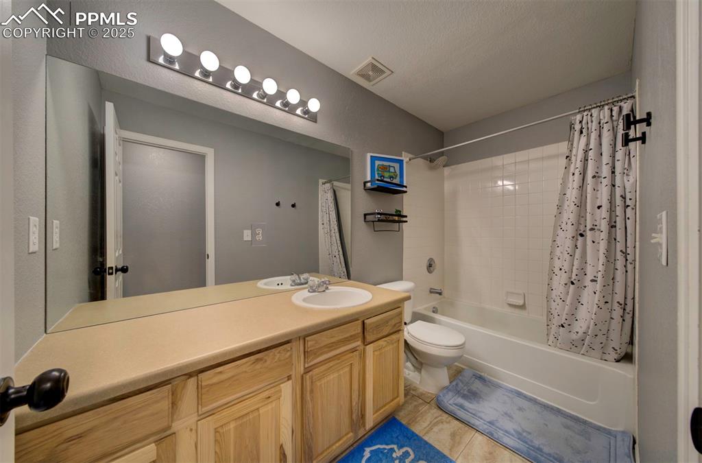 Image 42 of 43: Full bath featuring shower / bath combo with shower curtain, vanity, and li