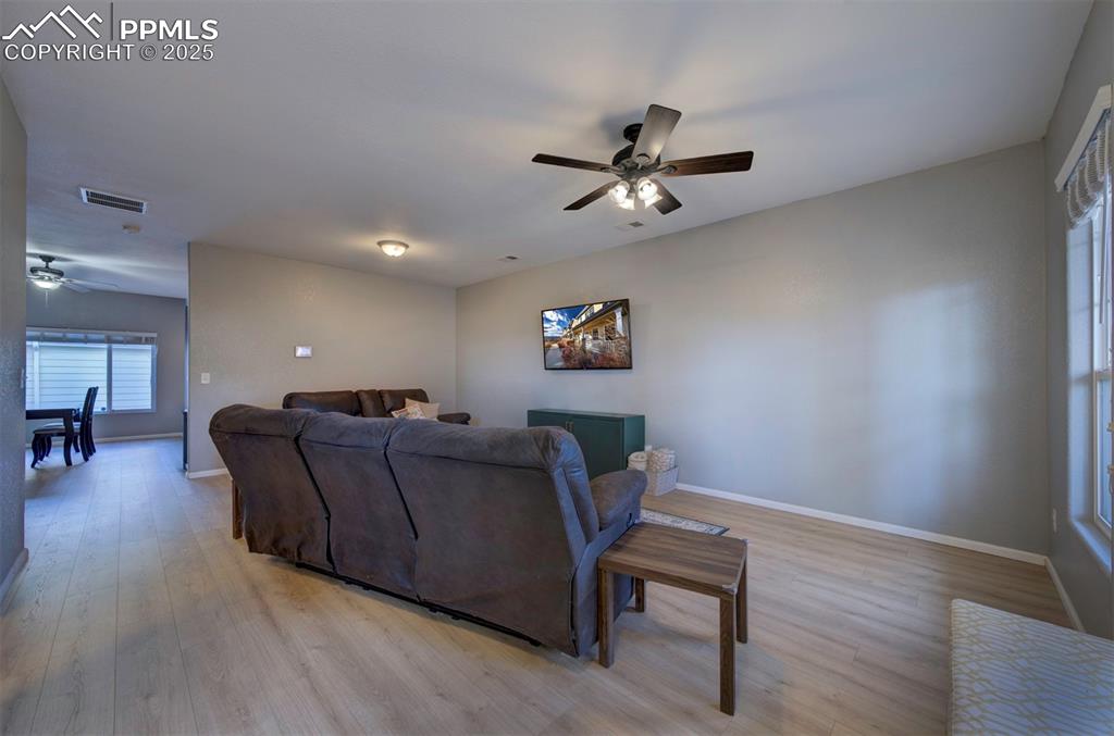 Image 9 of 43: Living room with a ceiling fan and light wood-type flooring