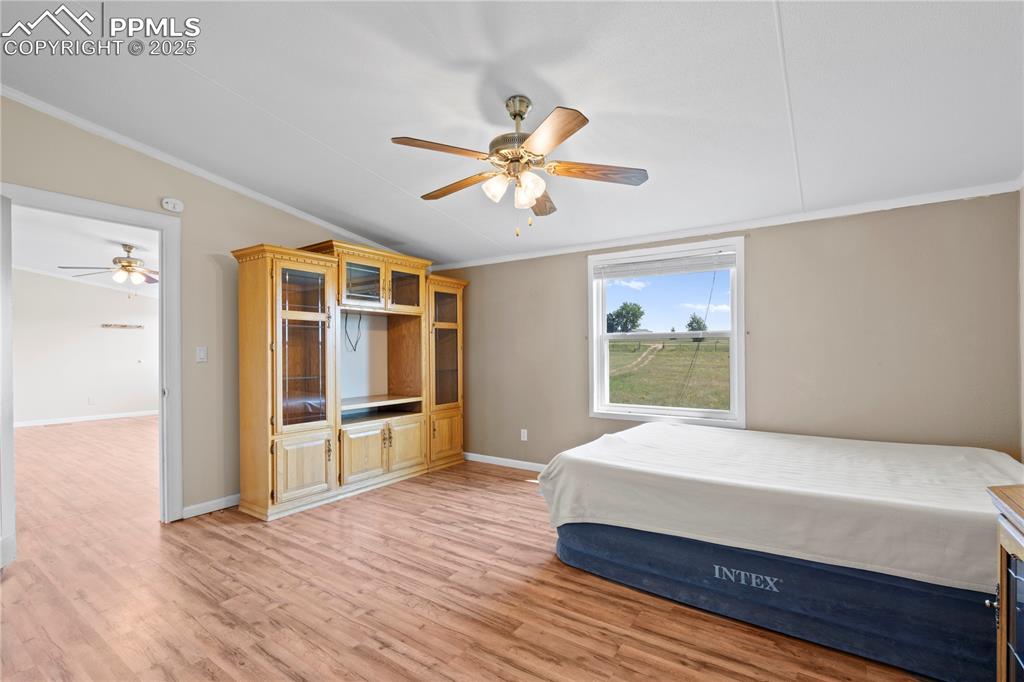 Image 12 of 29: Bedroom with crown molding, light wood-style flooring, and ceiling fan