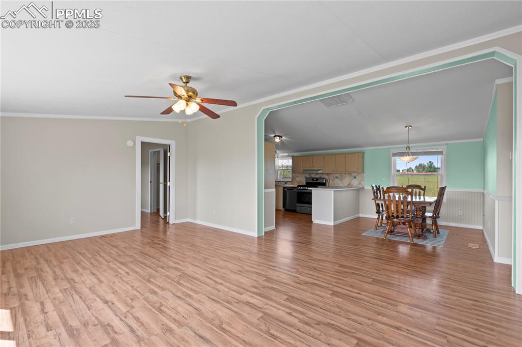 Image 3 of 29: Unfurnished living room with ornamental molding, plenty of natural light, a