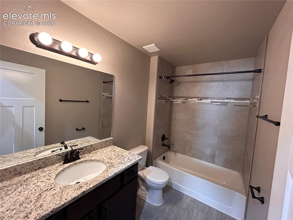 Image 18 of 24: Bathroom featuring a granite-finish vanity countertop with an undermount si