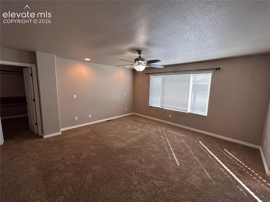 Image 19 of 24: Spacious room featuring neutral carpeting, a ceiling fan with integrated li