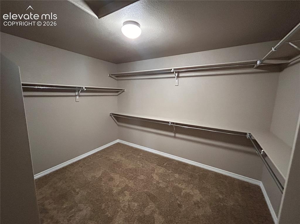 Image 21 of 24: Interior closet featuring multiple levels of shelving and hanging rods