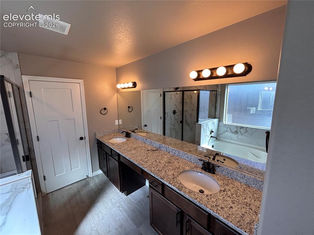 Image 22 of 24: Dual vanity with granite countertops, undermount sinks, and dark wood-finis