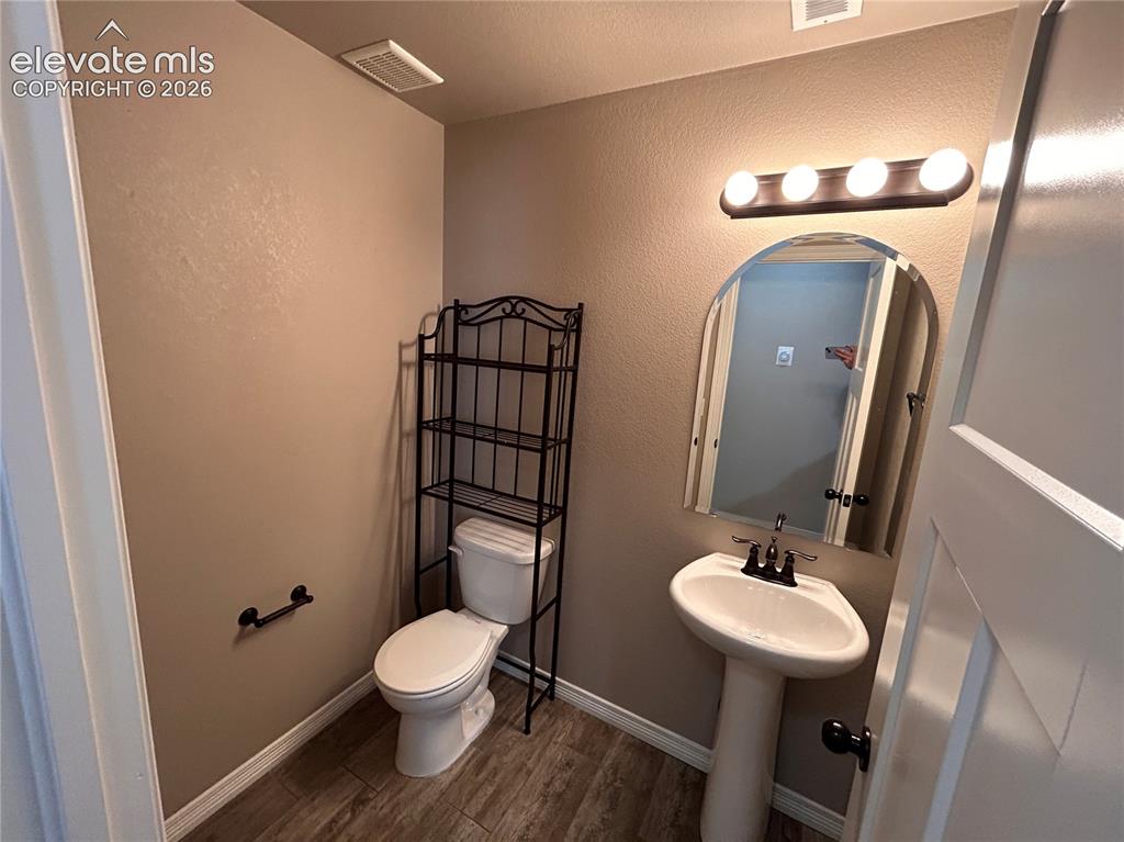 Image 4 of 24: Powder room featuring a white pedestal sink with a dark bronze faucet, an a
