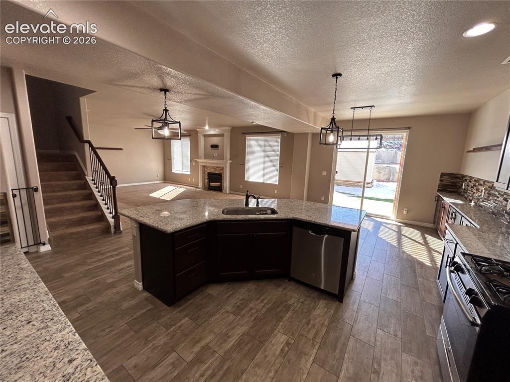 Image 5 of 24: Open-concept living space featuring a central kitchen island with a built-i