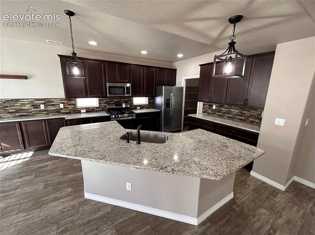 Image 8 of 24: Kitchen featuring a U-shaped island with an undermount sink, granite counte