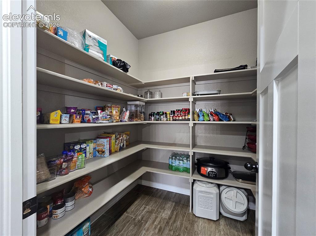 Image 9 of 24: Expansive walk-in pantry featuring abundant built-in shelving, wood-finish