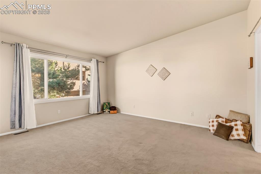 Image 13 of 30: Spacious master bedroom featuring a large picture window.