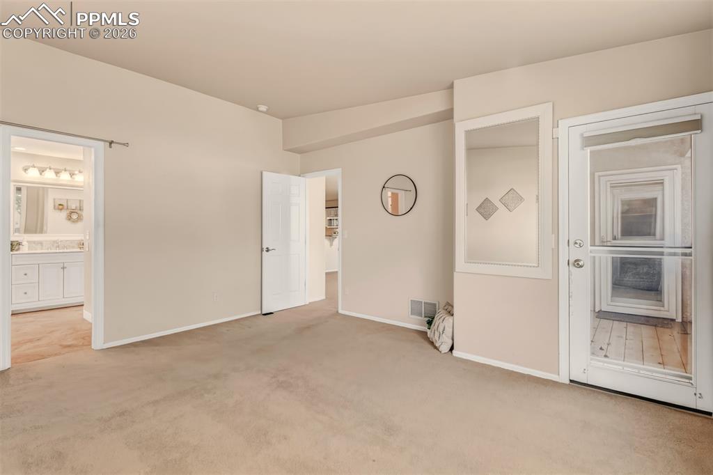 Image 14 of 30: Master bedroom with direct access to the rear covered patio.