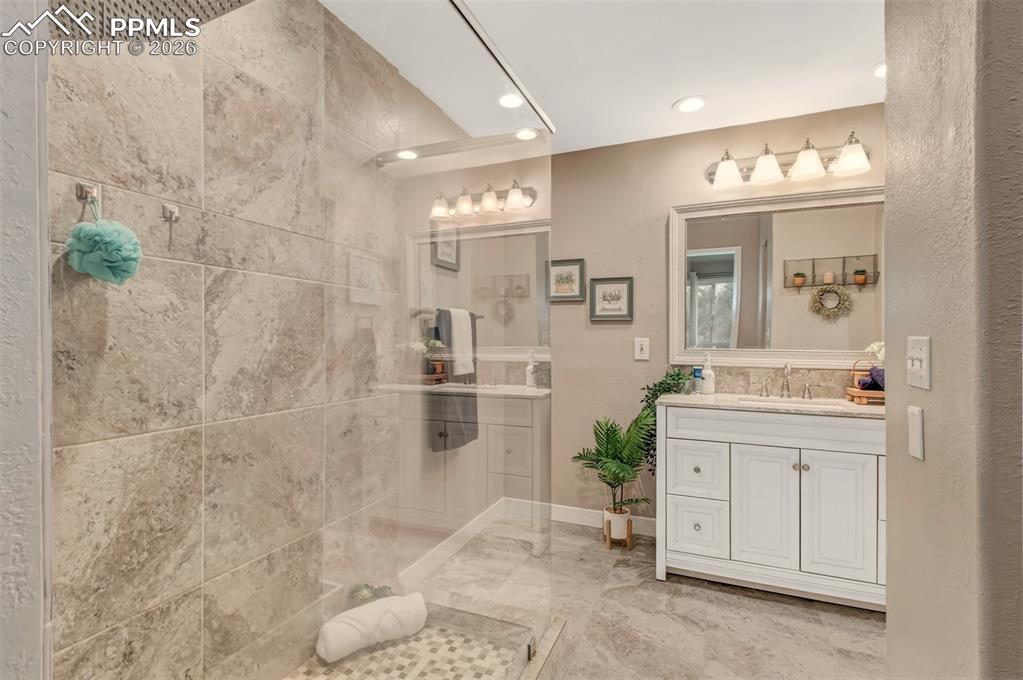 Image 16 of 30: Master bathroom featuring a glass shower, tile floors and a stylish vanity.