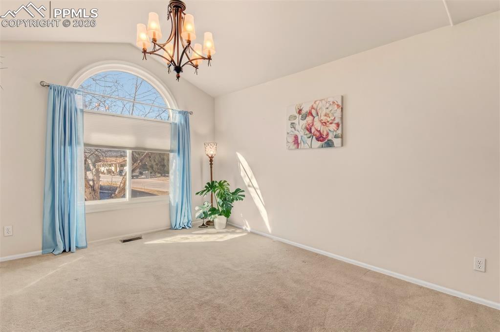 Image 2 of 30: Formal dining room featuring a stunning arched window and soaring vaulted c