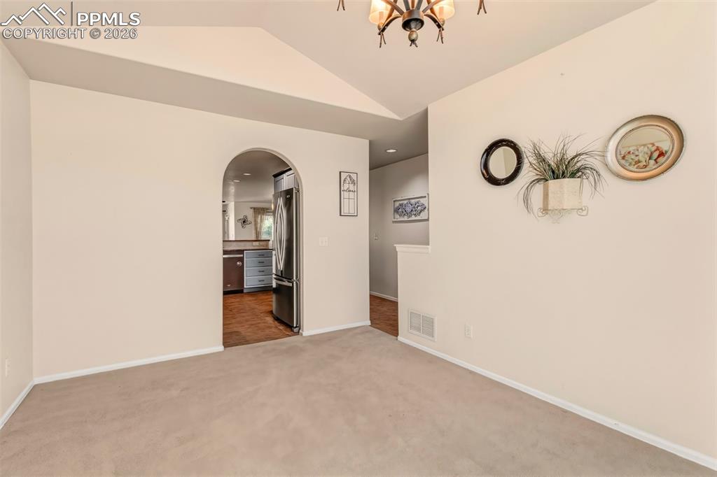 Image 3 of 30: Another view of formal dining room featuring  a charming arched entry that 