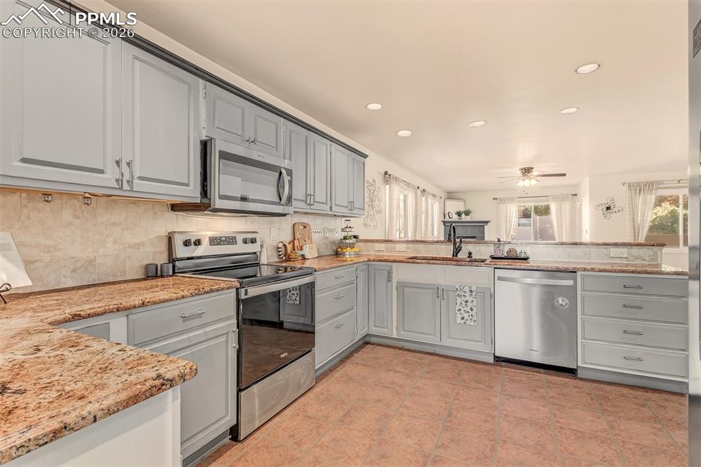 Image 4 of 30: Thoughtfully designed kitchen offering granite countertops, abundant cabine