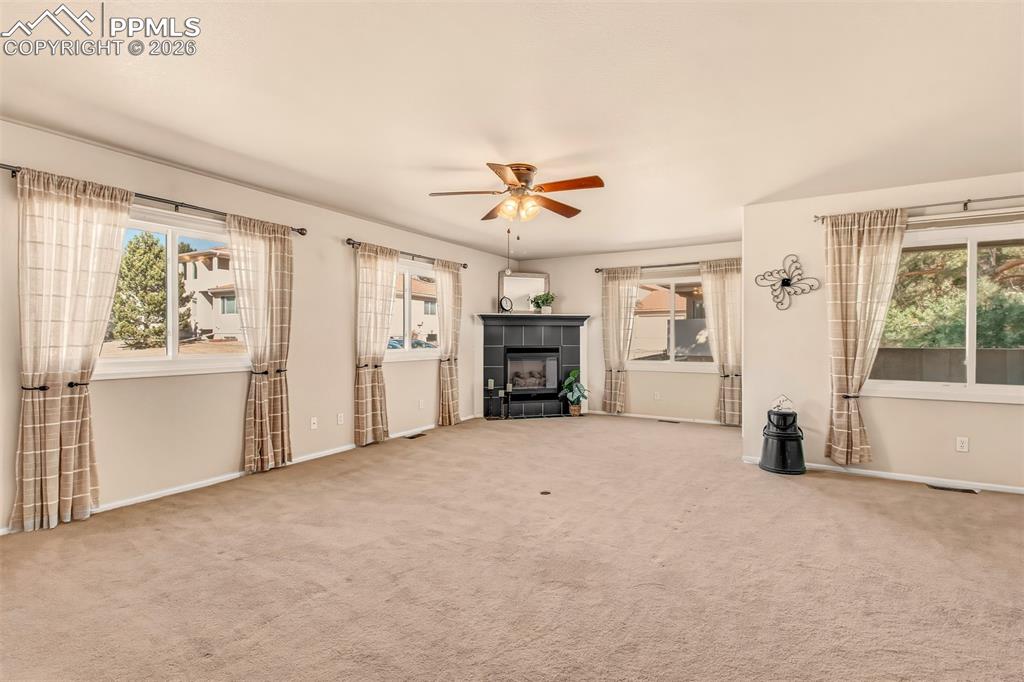 Image 8 of 30: Bright living room featuring a cozy gas fireplace and an abundance of windo
